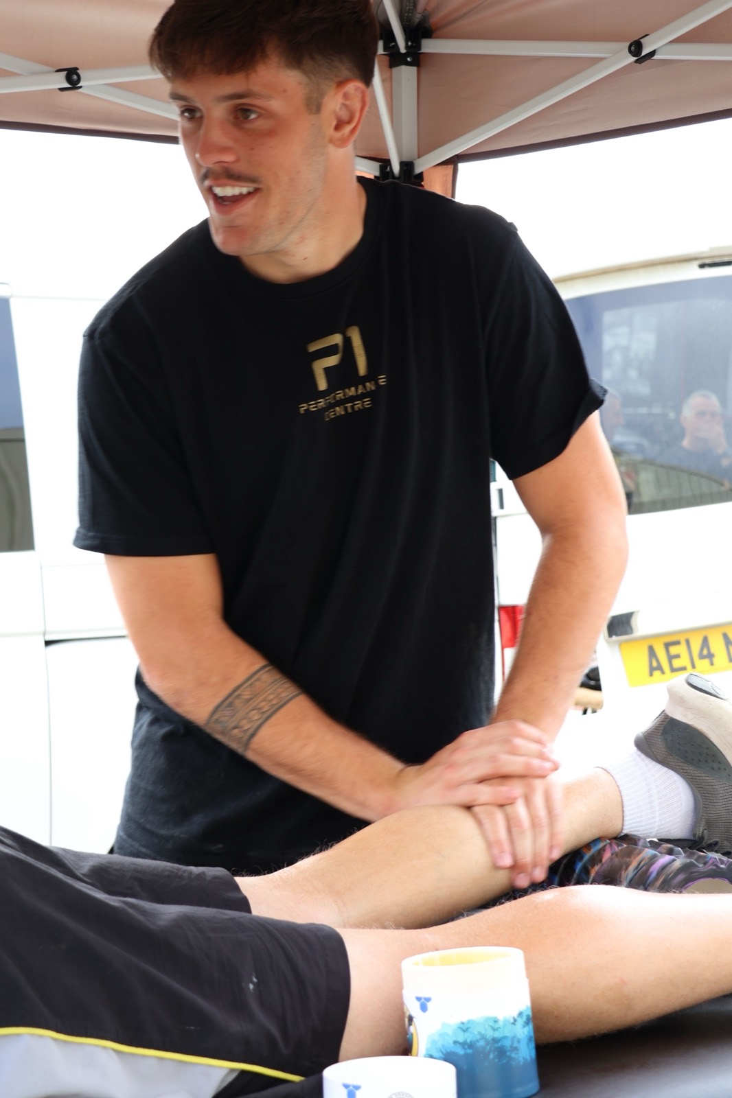 Iestyn smiling during a treatment session at a community event